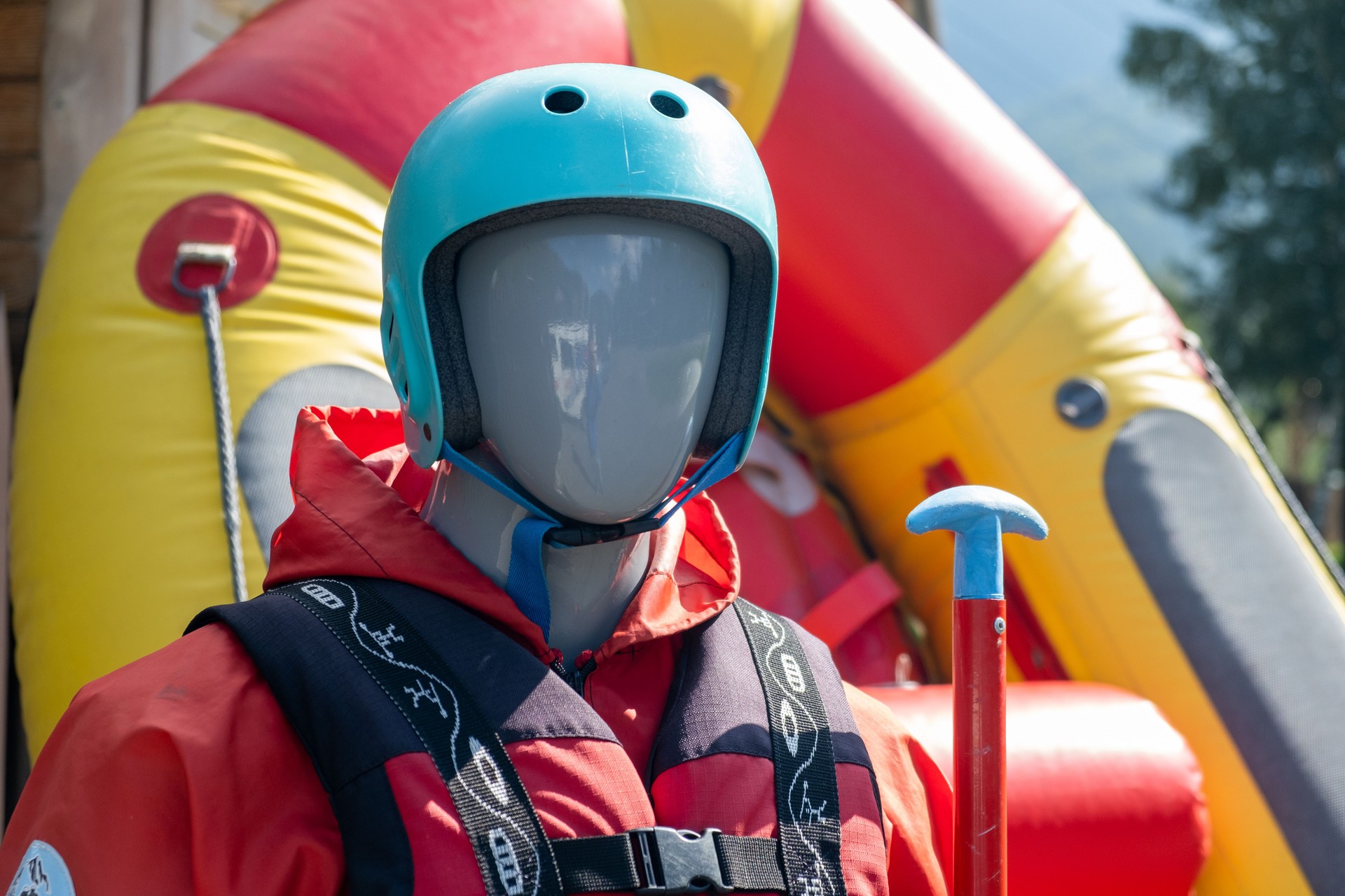A mannequin in a red life jacket next to an inflatable boat